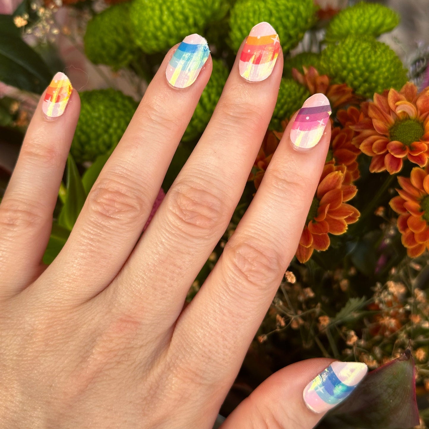 Roze nude basis met op elke nagel een ander kleurrijk regenboog met chrome finish