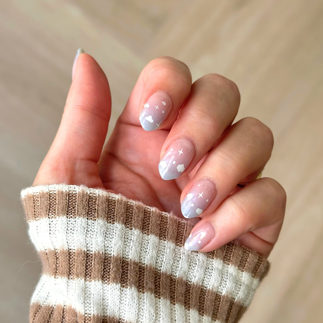 Zachte overgang van blauw naar wit/doorzichtig met kleine witte wolkjes voor een dromerige en verfijnde nail art gellaksticker