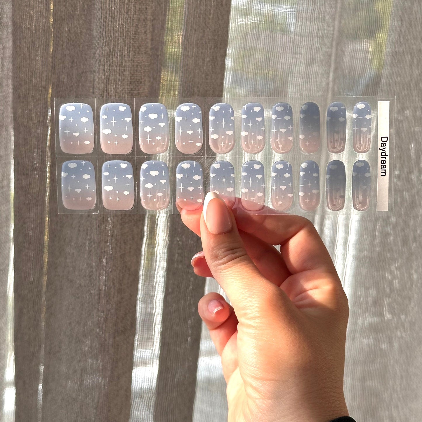 Zachte overgang van blauw naar wit/doorzichtig met kleine witte wolkjes voor een dromerige en verfijnde nail art