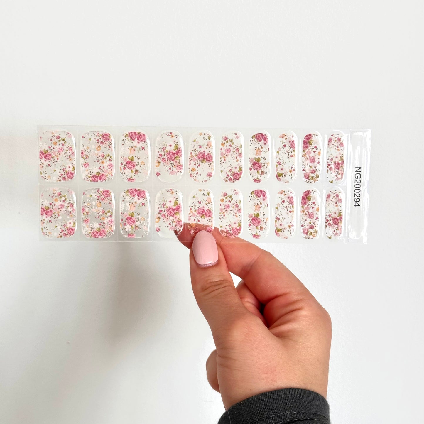 Nail art stickers met een volledig transparante basis en kleurrijke bloemen voor een levendige, vrolijke manicure, in de kleuren roze, wit en groen