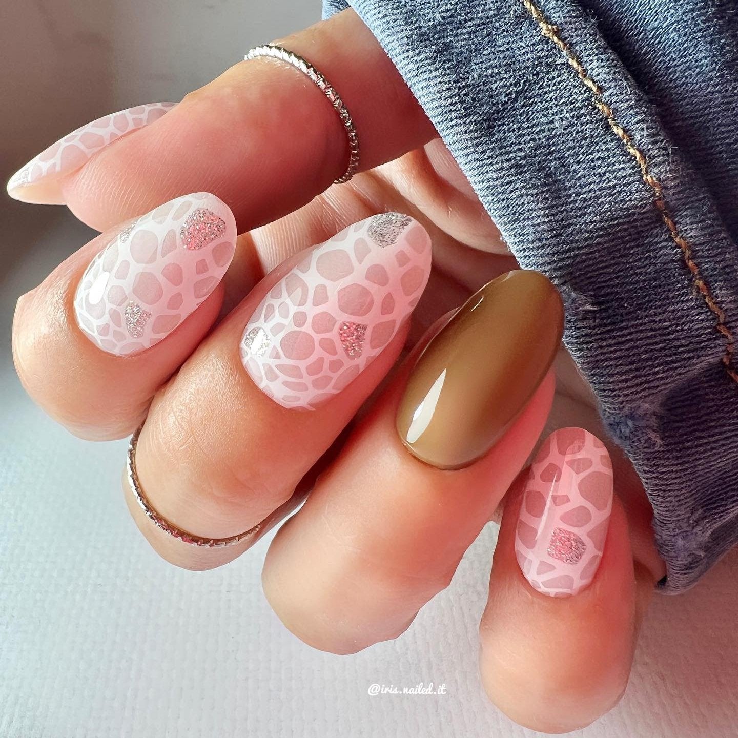 Gellakstickers met op sommige nagels effen bruin en op andere nagels witte panterprint, afgewerkt met subtiele zilveren glitter.