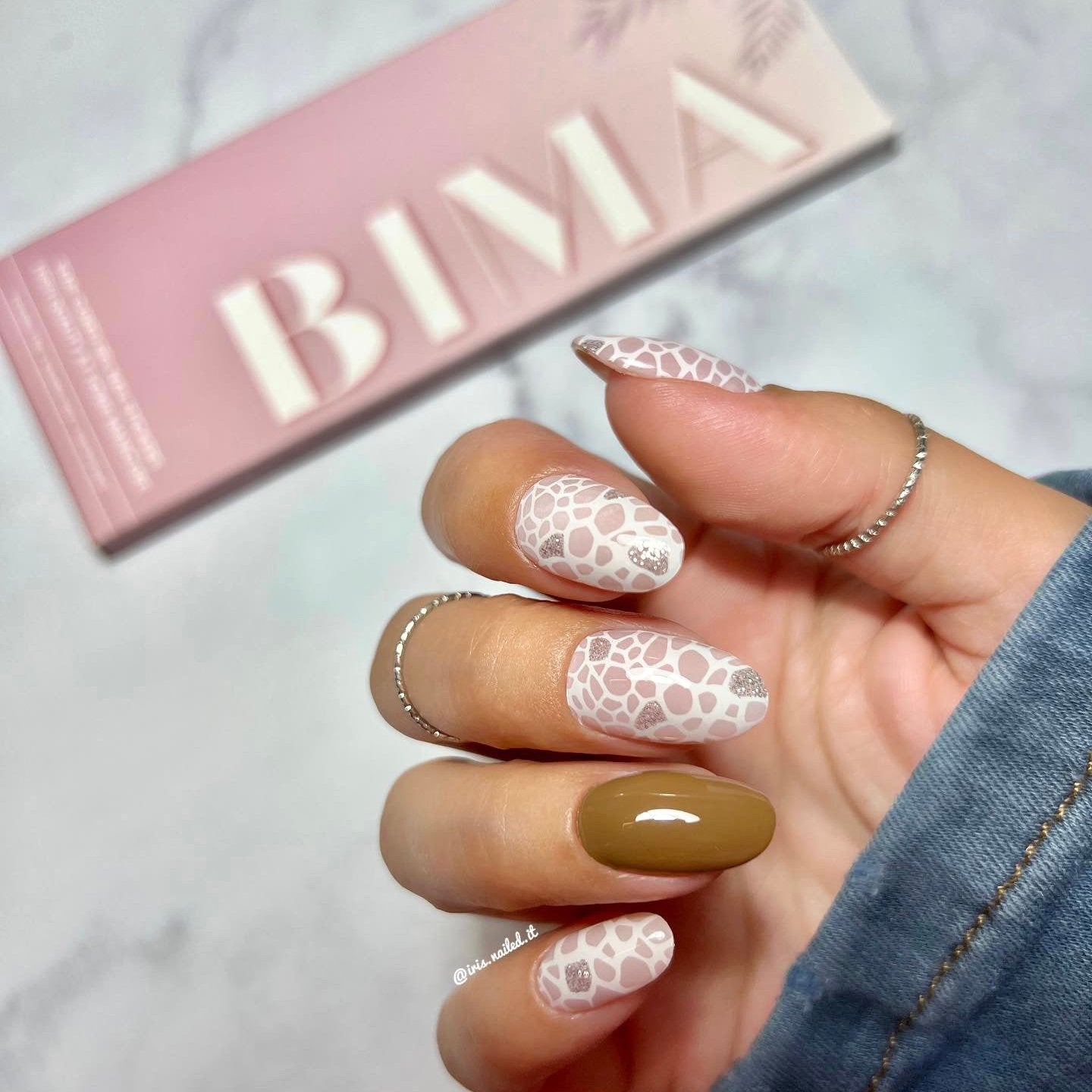 Gellakstickers met op sommige nagels effen bruin en op andere nagels witte panterprint, afgewerkt met subtiele zilveren glitter.