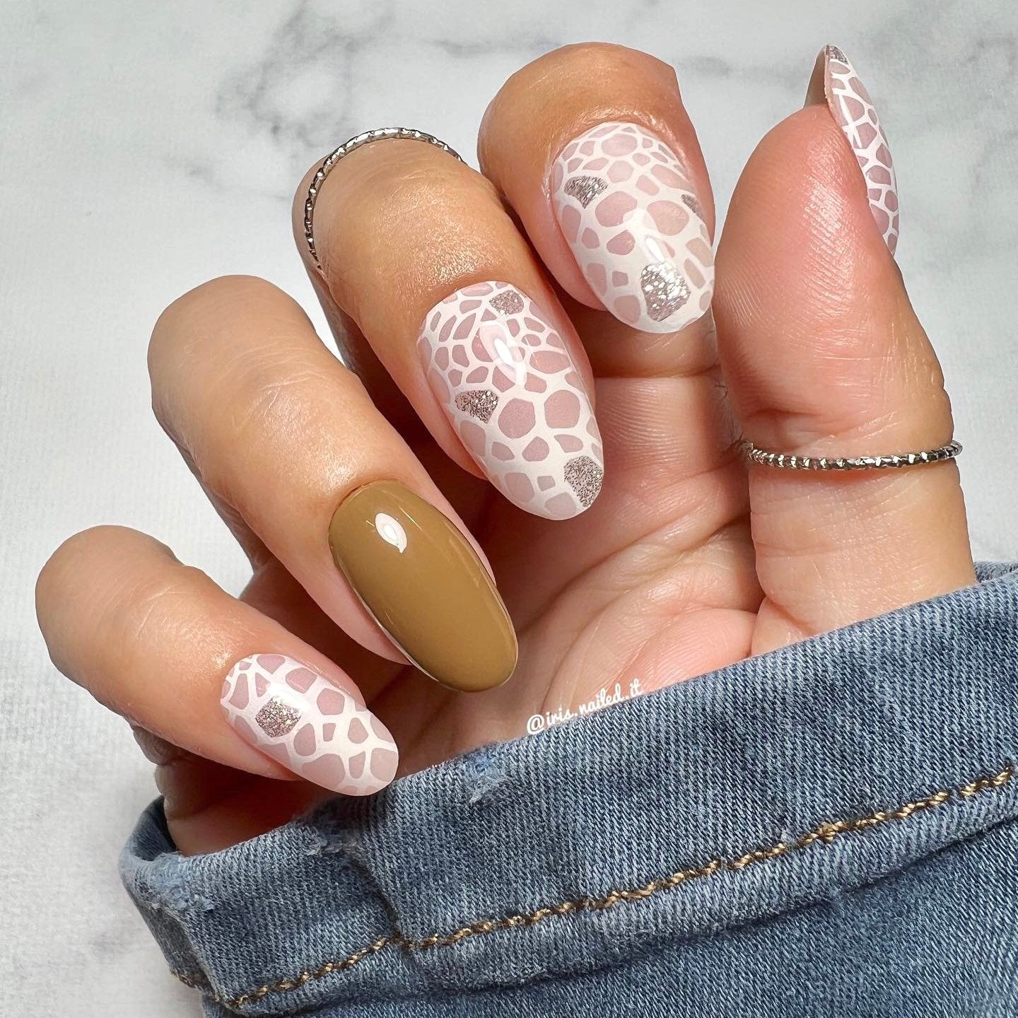 Gellakstickers met op sommige nagels effen bruin en op andere nagels witte panterprint, afgewerkt met subtiele zilveren glitter.