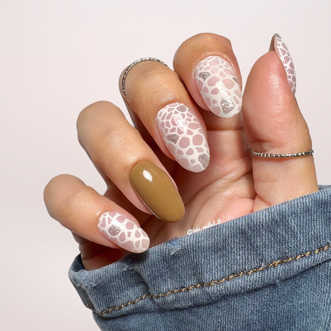 Gellakstickers met op sommige nagels effen bruin en op andere nagels witte panterprint, afgewerkt met subtiele zilveren glitter.