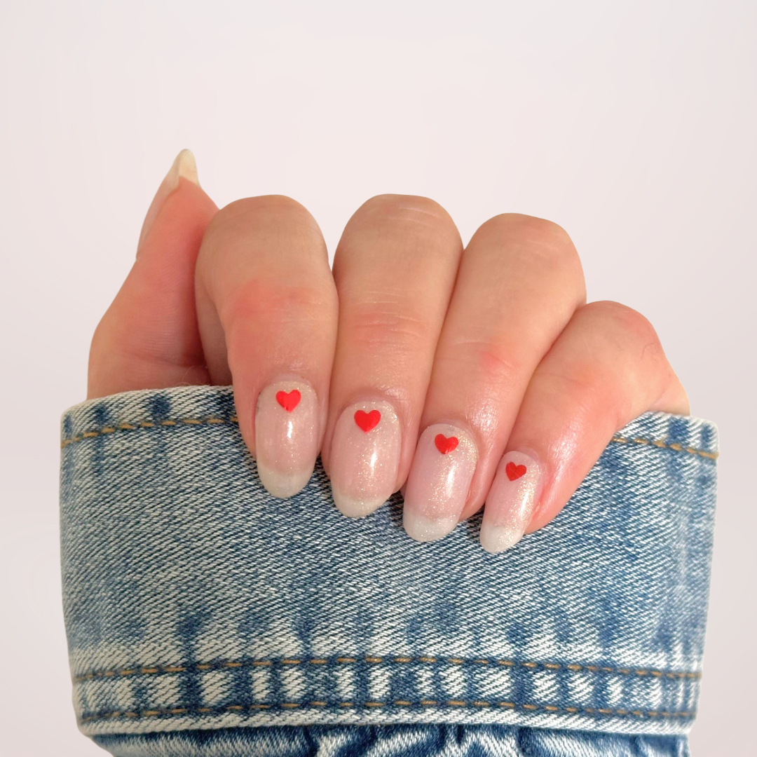 Semi-transparante witte gellakstickers met subtiele glitter en een klein rood hartje