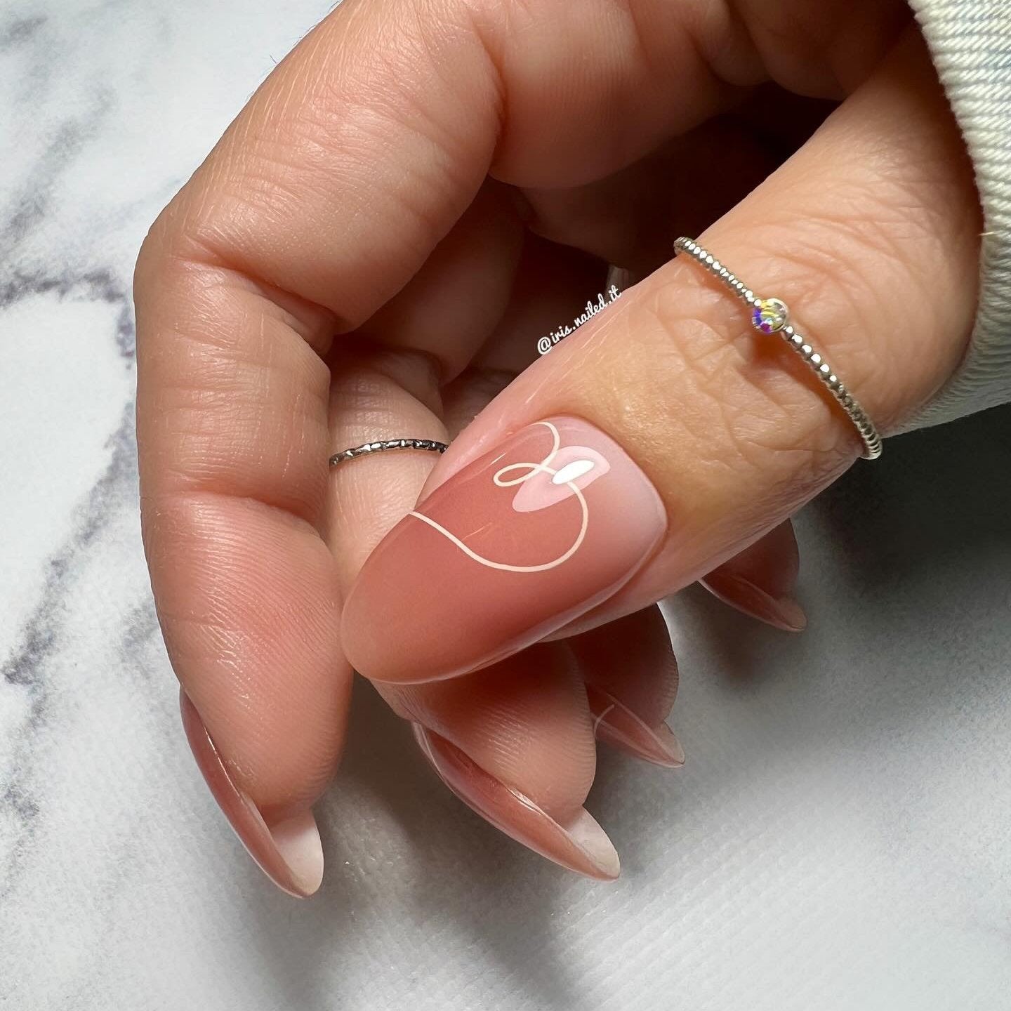 Gellakstickers met een nude roze/bruinige basis en subtiele witte hartvormige swirls