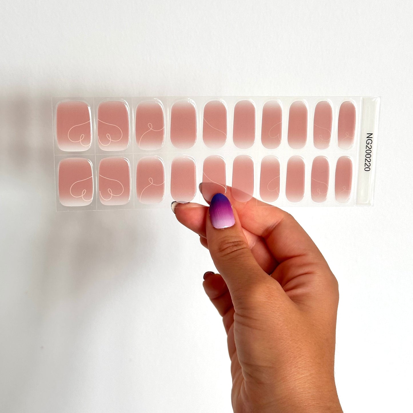 Gellakstickers met een nude roze/bruinige basis en subtiele witte hartvormige swirls