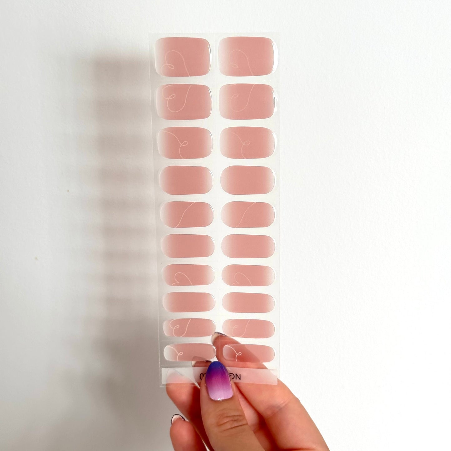 Gellakstickers met een nude roze/bruinige basis en subtiele witte hartvormige swirls