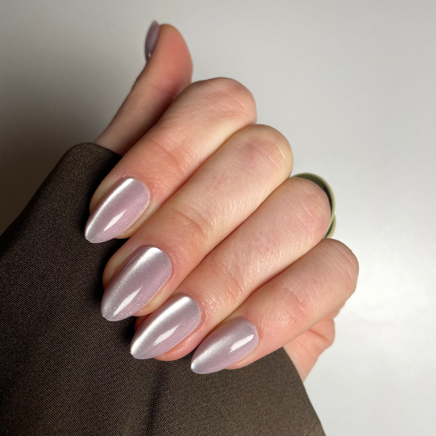 Ovale cat eye press-on nagels met een diepgekleurde basis en een magnetisch glanseffect dat met het licht beweegt.