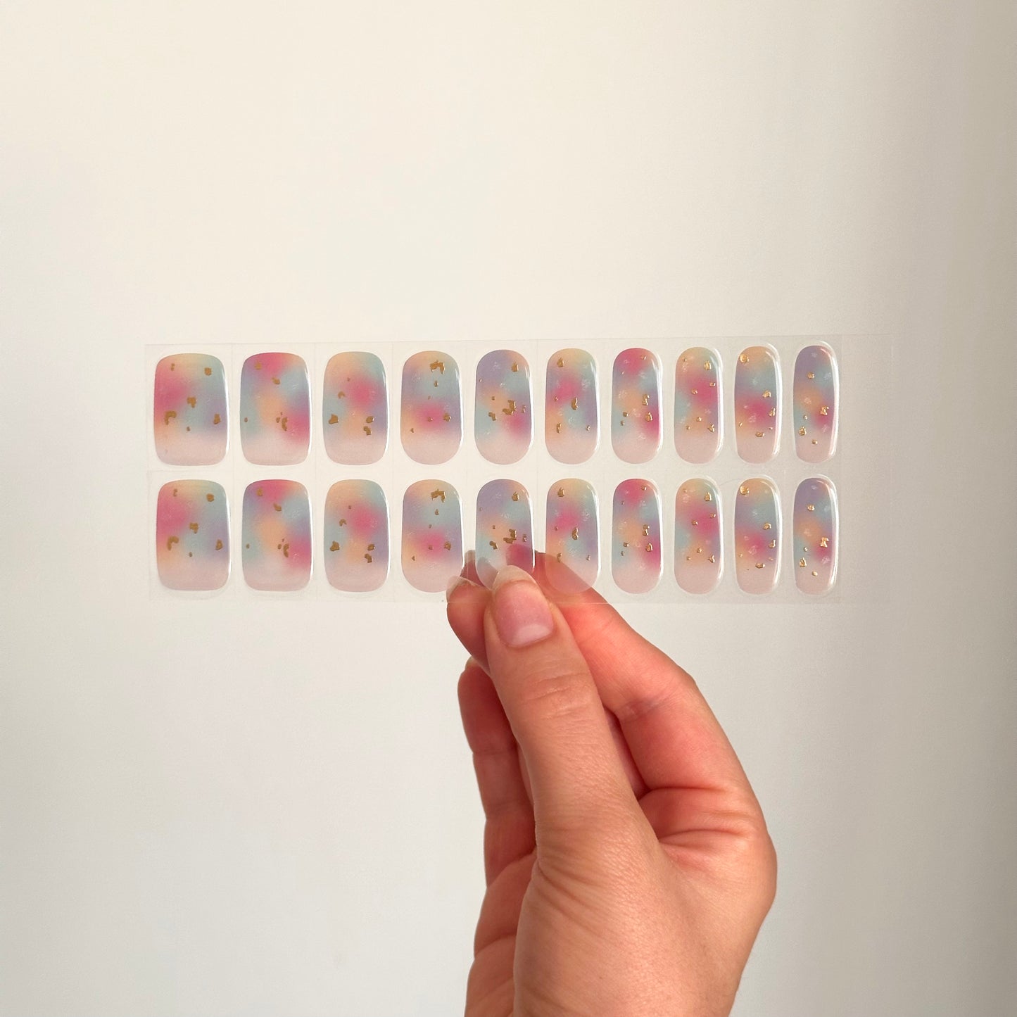 semi-transparante gellakstickers in marble-effect, met lichte kleuren (roze,blauw,oranje,paars) en subtiele gouden details