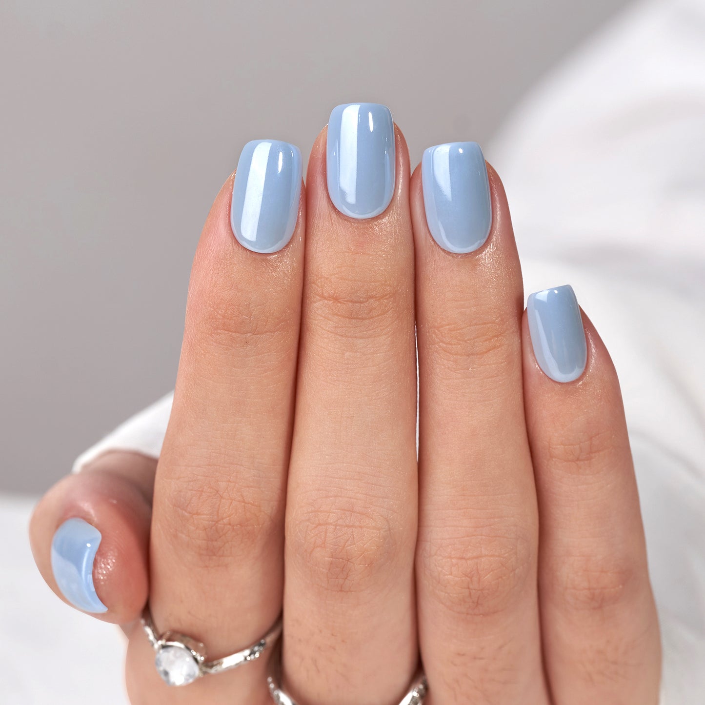 effen lichtblauwe plaknagels in een short square vorm. De nagels hebben een gladde, glanzende afwerking en stralen eenvoud en frisheid uit, perfect voor een minimalistische en zomerse look.