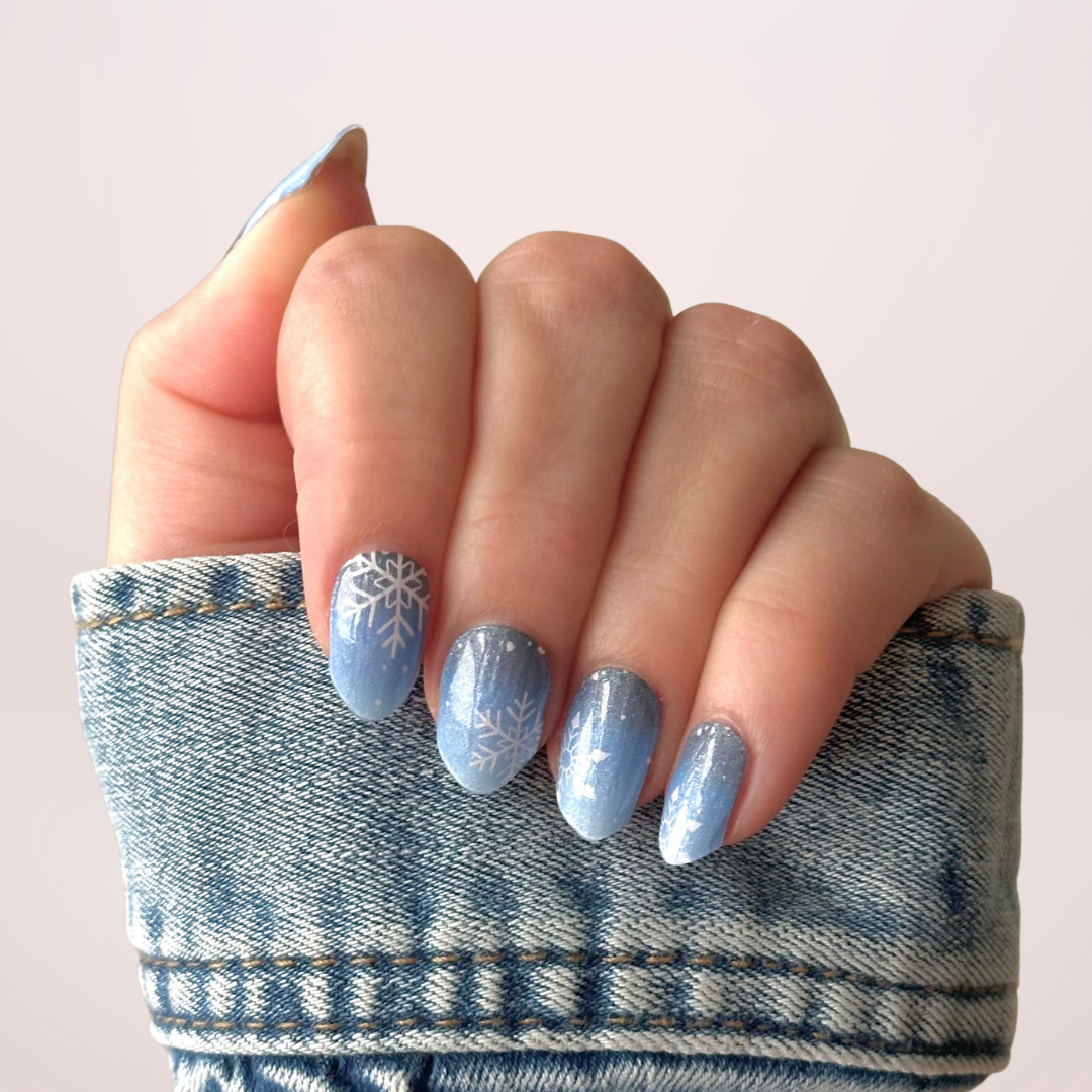 Blauwe ombre nagels met subtiele glinsters en witte sneeuwvlokken nail art, ideaal voor winter en feestdagen
