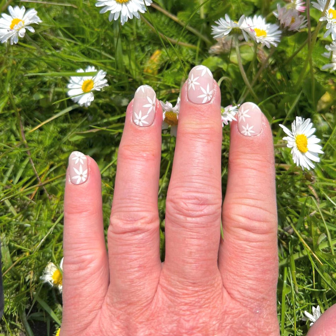 Licht roze, nude gel nagelstickers met witte bloemetjes voor een romantische, verfijnde en tijdloze manicure