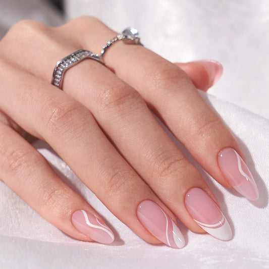 Lange amandelvormige plaknagels met een roze basis en elegante witte swirls, perfect voor een trendy manicure.