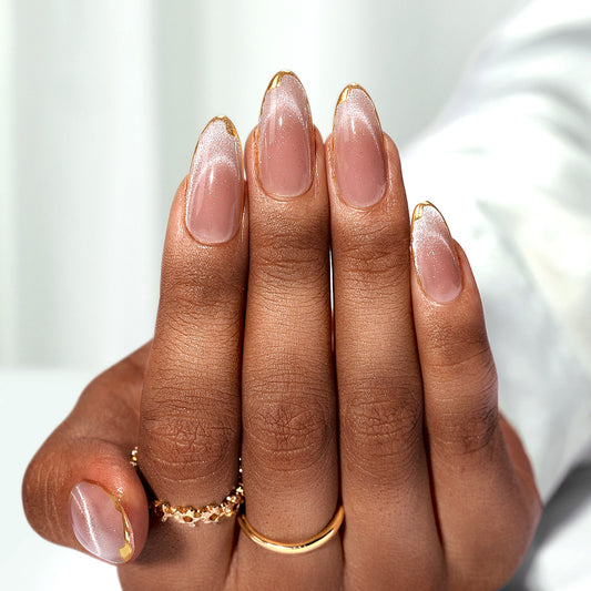 Nude press-on nagels met meer glitters richting de tips en een subtiele gouden lijn voor een luxe uitstraling.