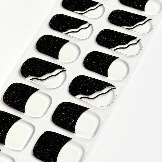 French manicure met transparante basis en zwarte diagonale tips met subtiele glitter