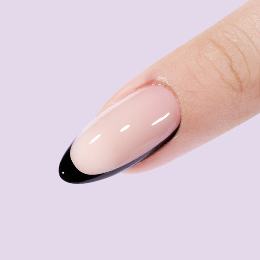 Lange almond press on nagels met in plaats van een witte tip een zwarte tip. De zwarte tip loopt aan 1 zijkant van de nagel door