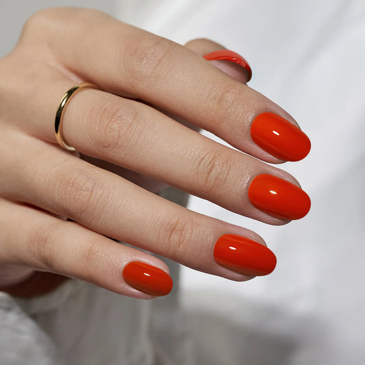 Close up van de zomerse rode plaknagels in ovale vorm van BIMA Nails
