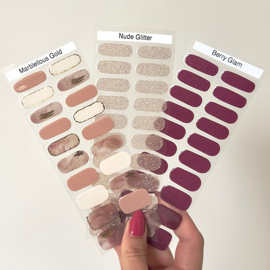De 3 gellaksticker stickervellen naast elkaar. Marblellous Gold; een nail art met elke nagel verschillend, roze marmeren nagels met gouden details en andere nagels verschillende effen nude kleuren. Nude Glitter; een mooie lichte nude glitter. Berry Glam; Een donkerpaarse / aubergine achtige kleur met subtiele shimmer erdoor. 