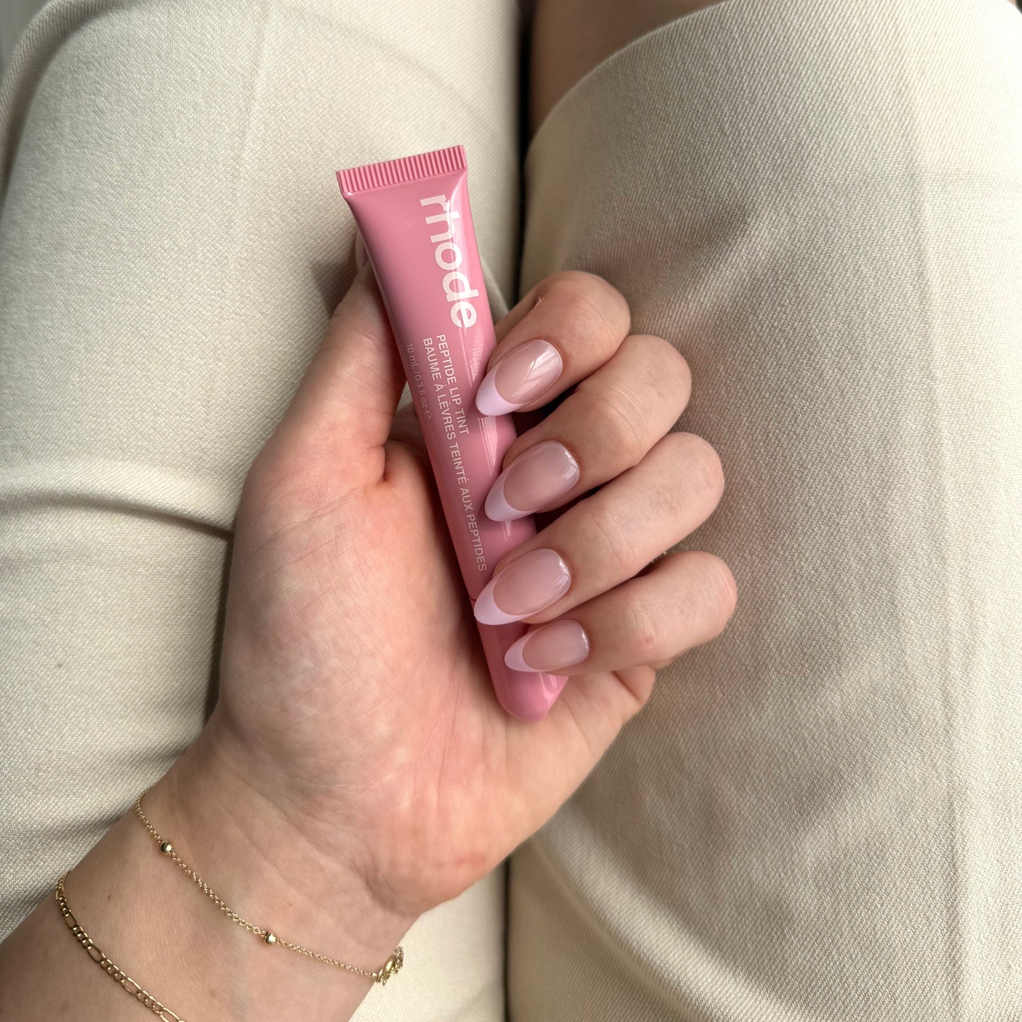 Roze french manicure press-ons en met een rhode lipgloss in de hand