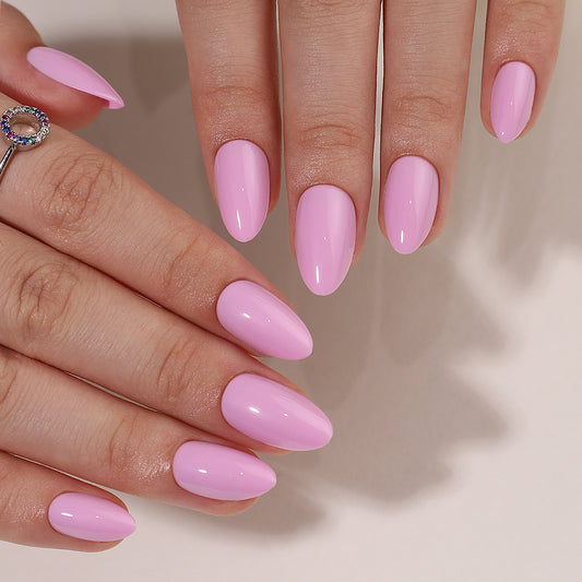 Je ziet 2 handen met press on nagels van BIMA Nails. Een mooie licht roze almond vormige nagel