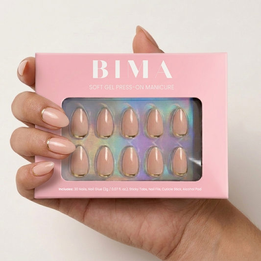 Nude basis press-on nail met onderaan een gouden lijn als detail in almond vorm nagel. 