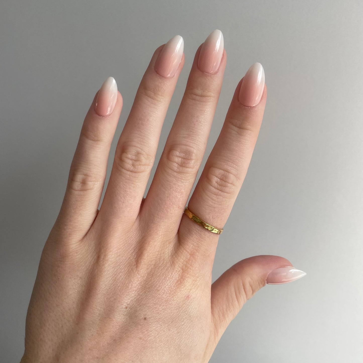Model draagt prachtige babyboom press on nagels een overgang van nude naar wit. Stijlvol en tijdloos van BIMA Nails